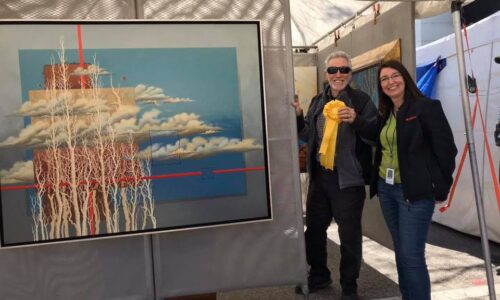 artist receiving ribbon next to painting at Bartow's Bloomin' Arts Festival