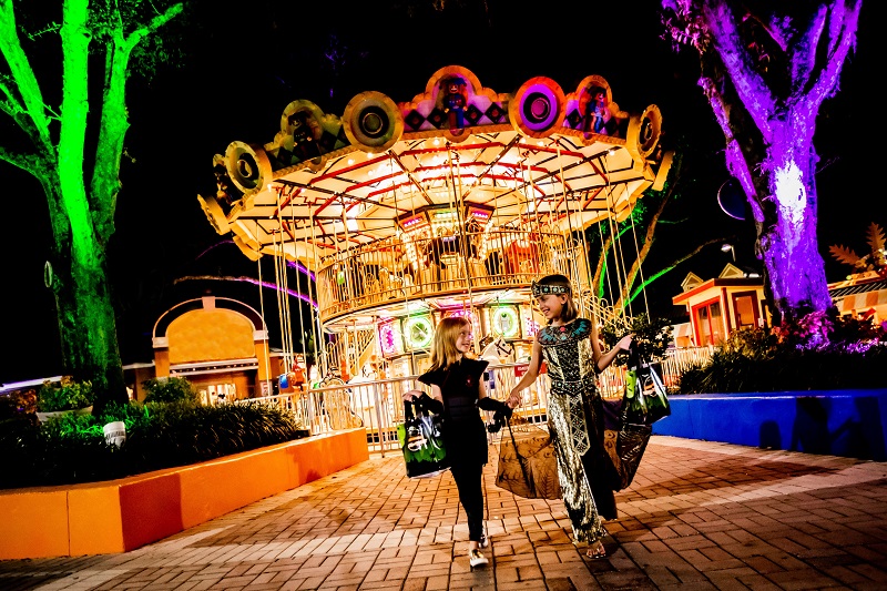 Two kids in costume at the carousel