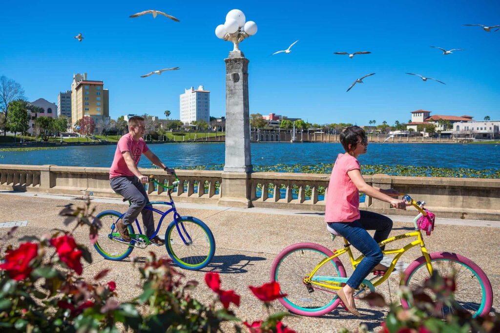 couple riding bikes around Lake Mirror in Lakeland