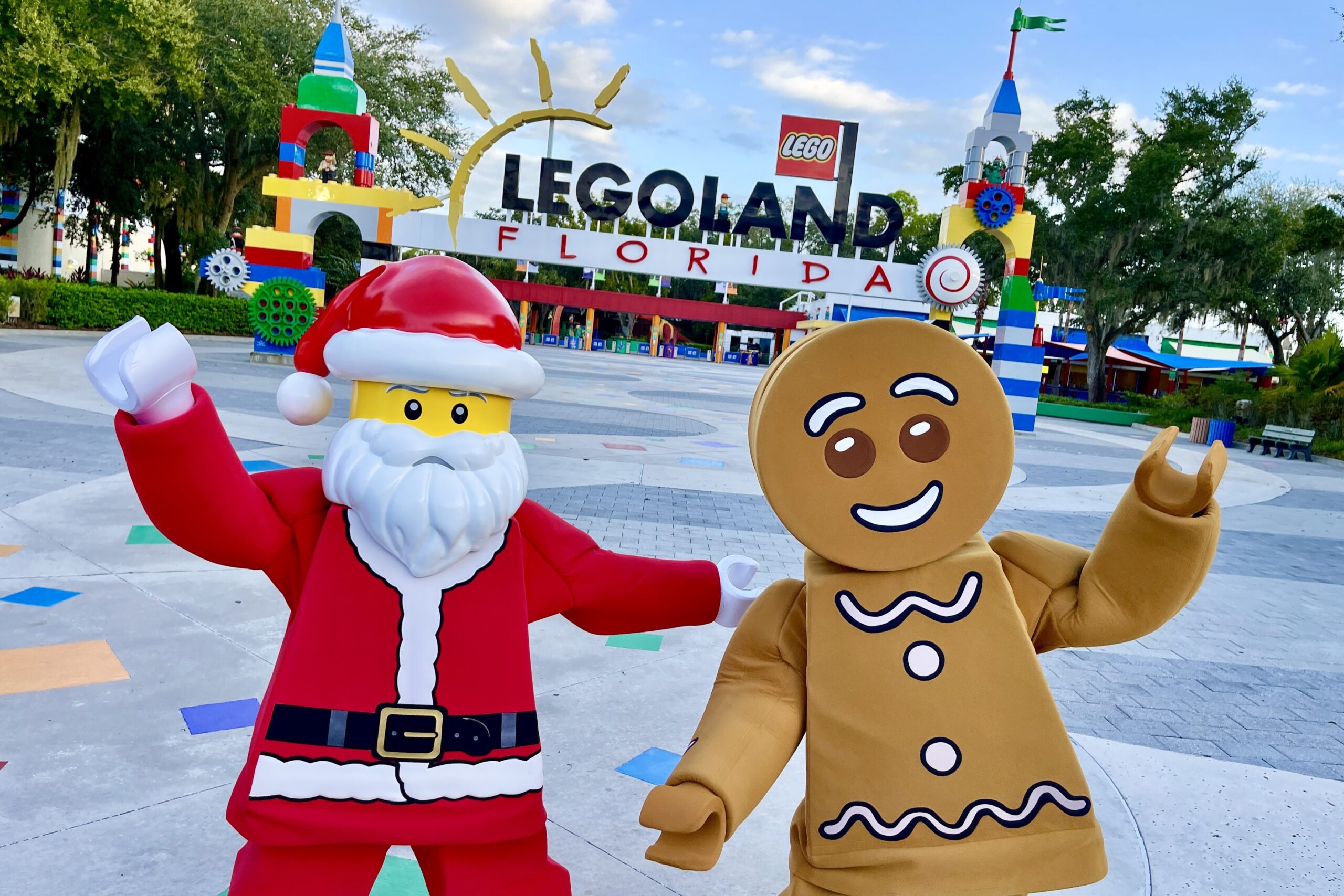 LEGO Santa and LEGO Gingerbread man standing outside LEGOLAND Florida Resort main entrance.