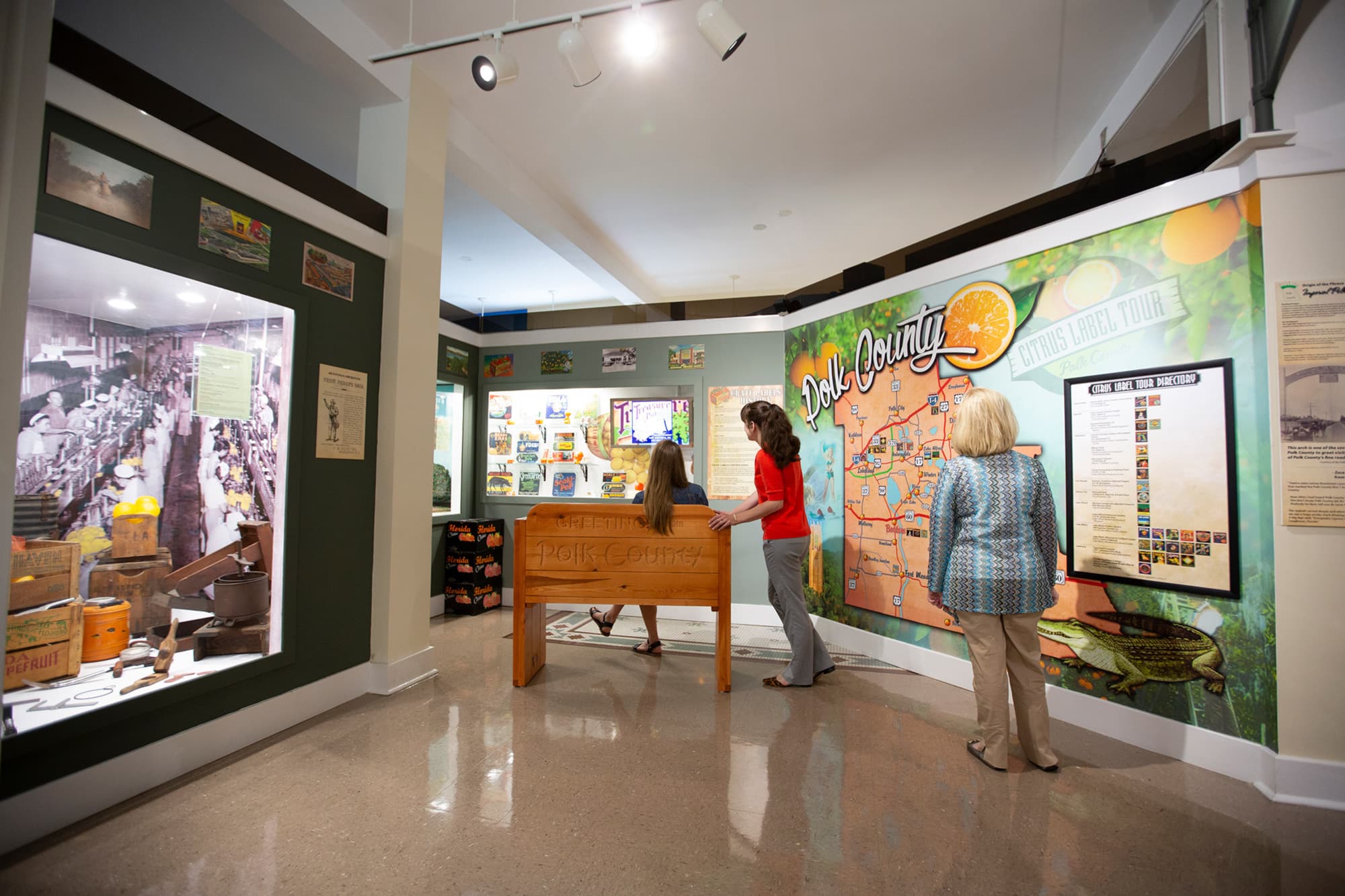 3 women looking at citrus themed Polk County exhibits inside Polk County History Center in Bartow, FL