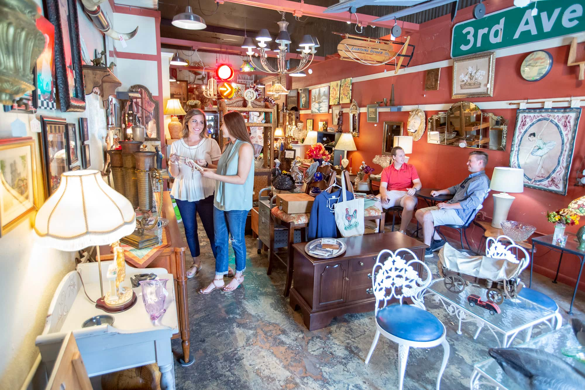 2 people shopping inside The Shop Across the Street in Lakeland, FL. Home decor and antique furniture on display.